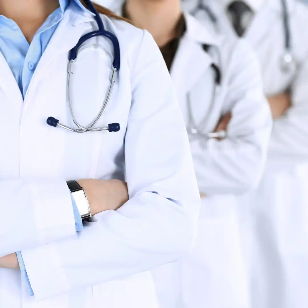 several doctors with white coats holding arms crossed
