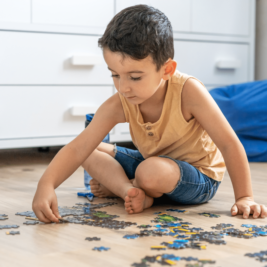 young Doc Blackstone seated on the floor solving a puzzle