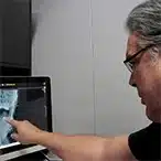 Doc Blackstone analysing a patient spinal X-ray in a holistic health assessment