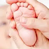 Gentle pediatric Tuina foot massage on an infant patient