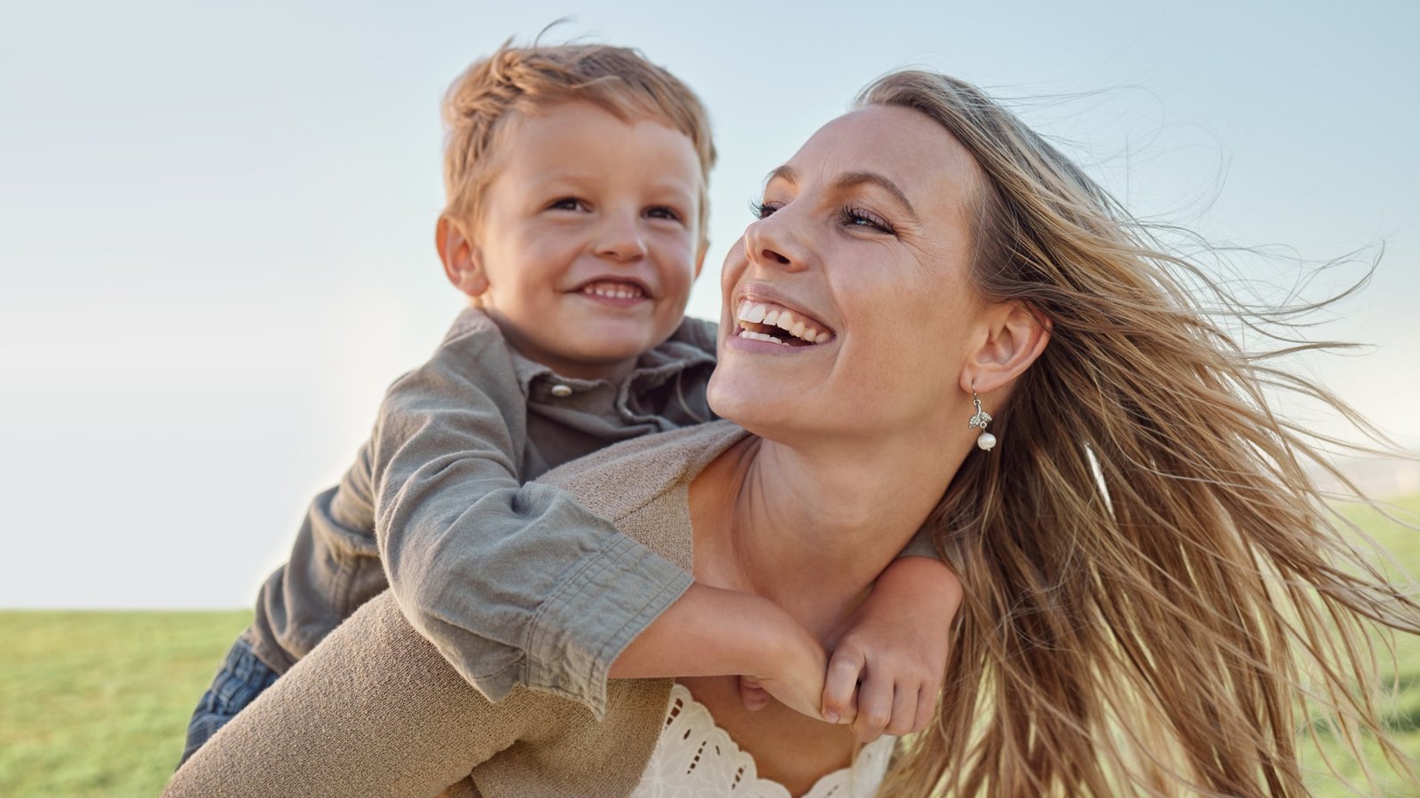 child laughing riding happy mother's back after pediatric acupuncture therapy from Doc Blackstone