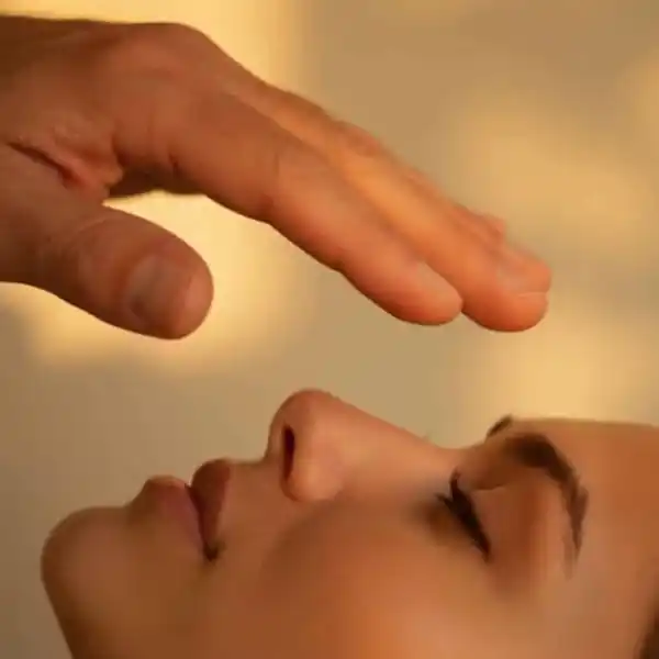 Doc Blackstone guiding Emotional Release Therapy session holding hand over lying woman's face